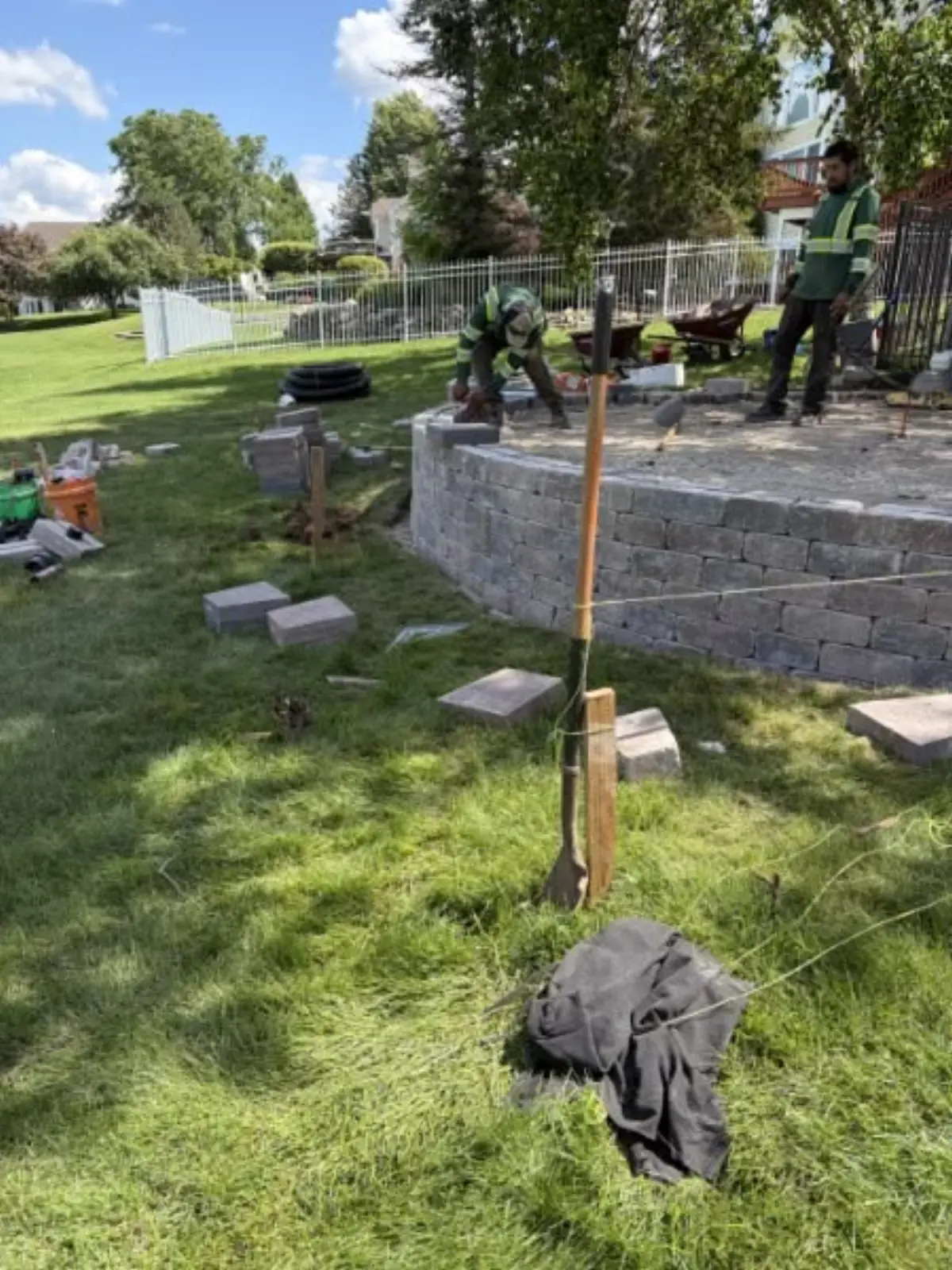 Hardscape crew constructing a raised retaining wall