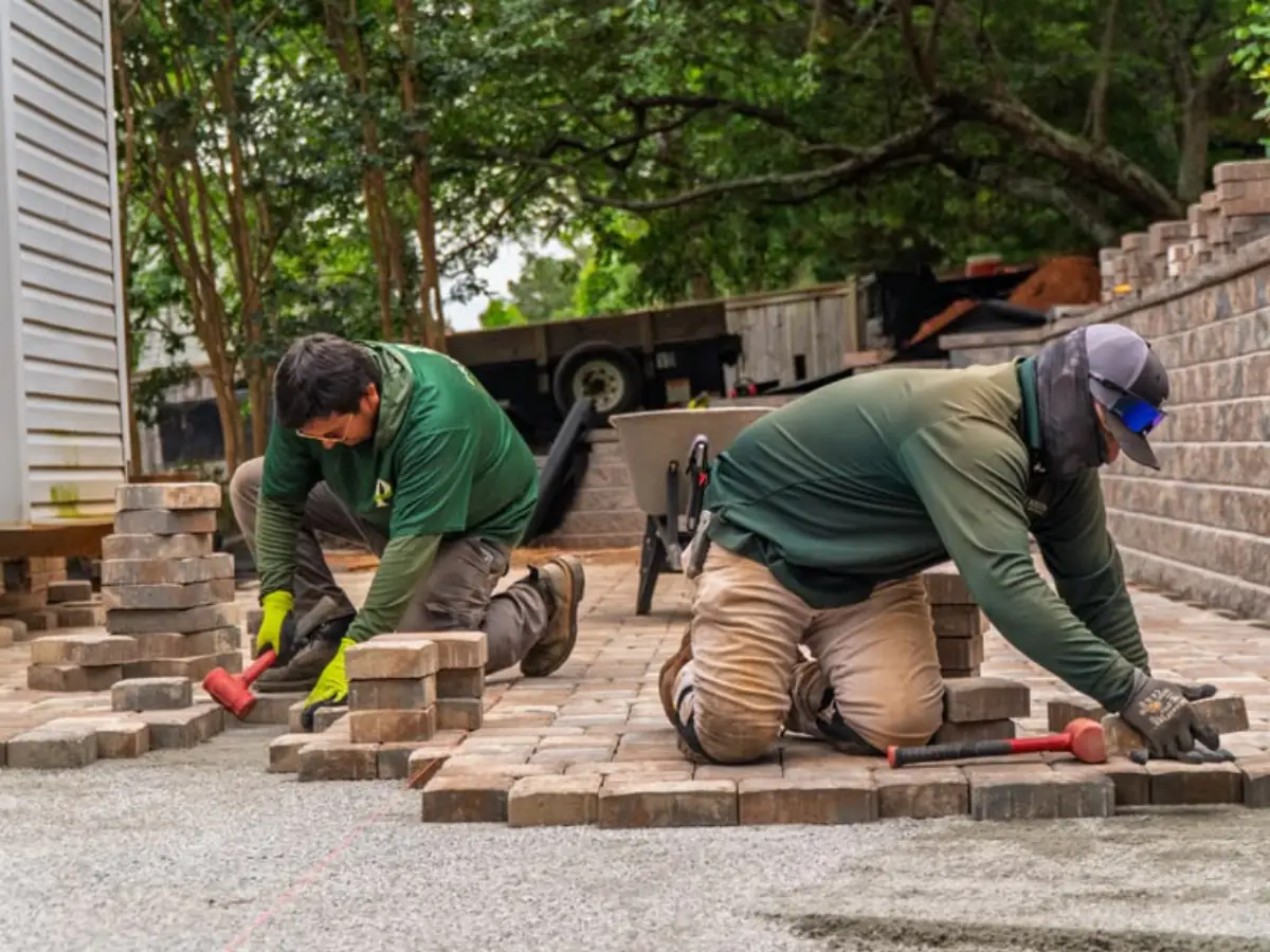 Hardscape crew installing interlocking pavement blocks