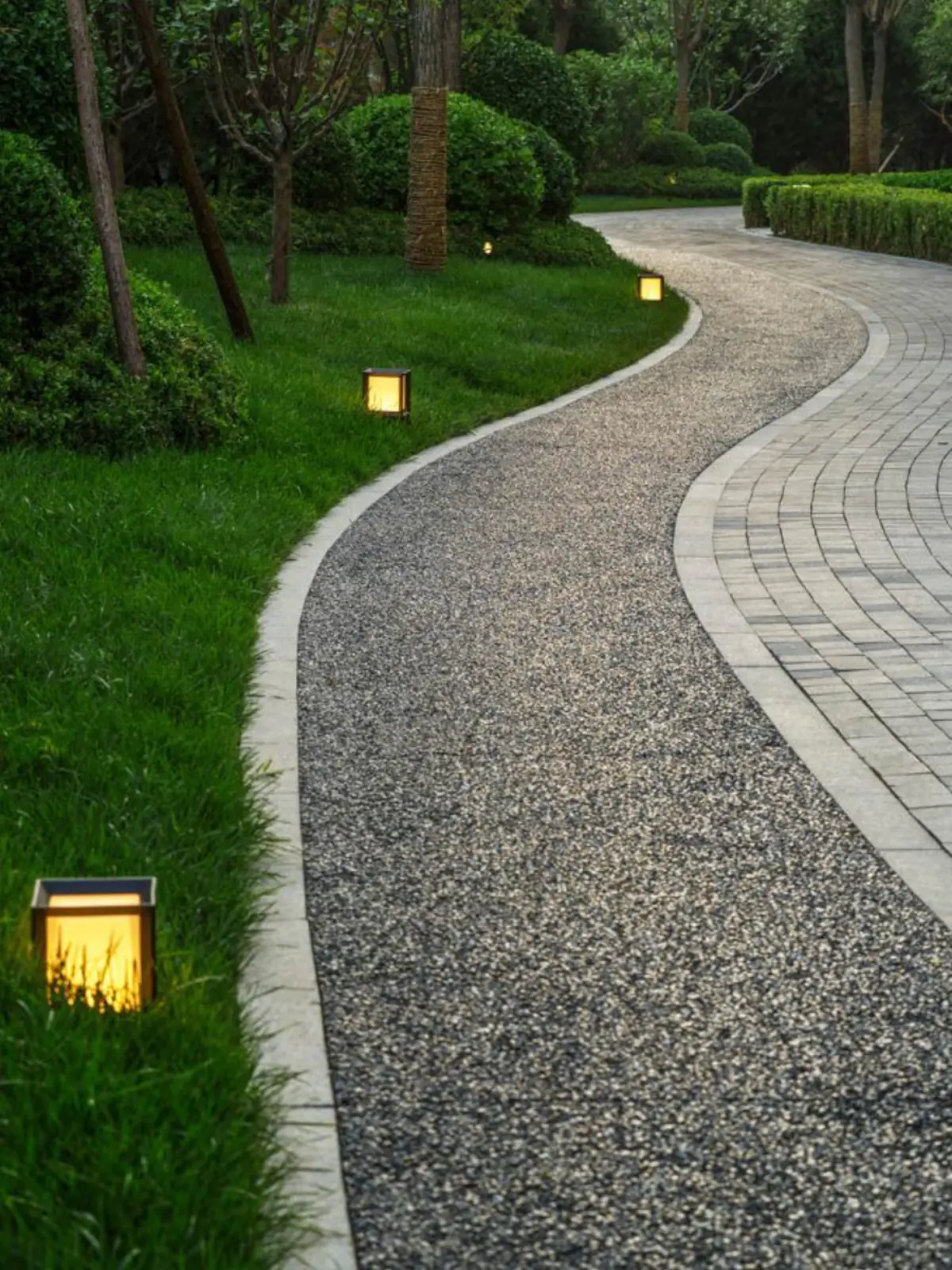 Curved aggregate garden pathway with landscape lighting
