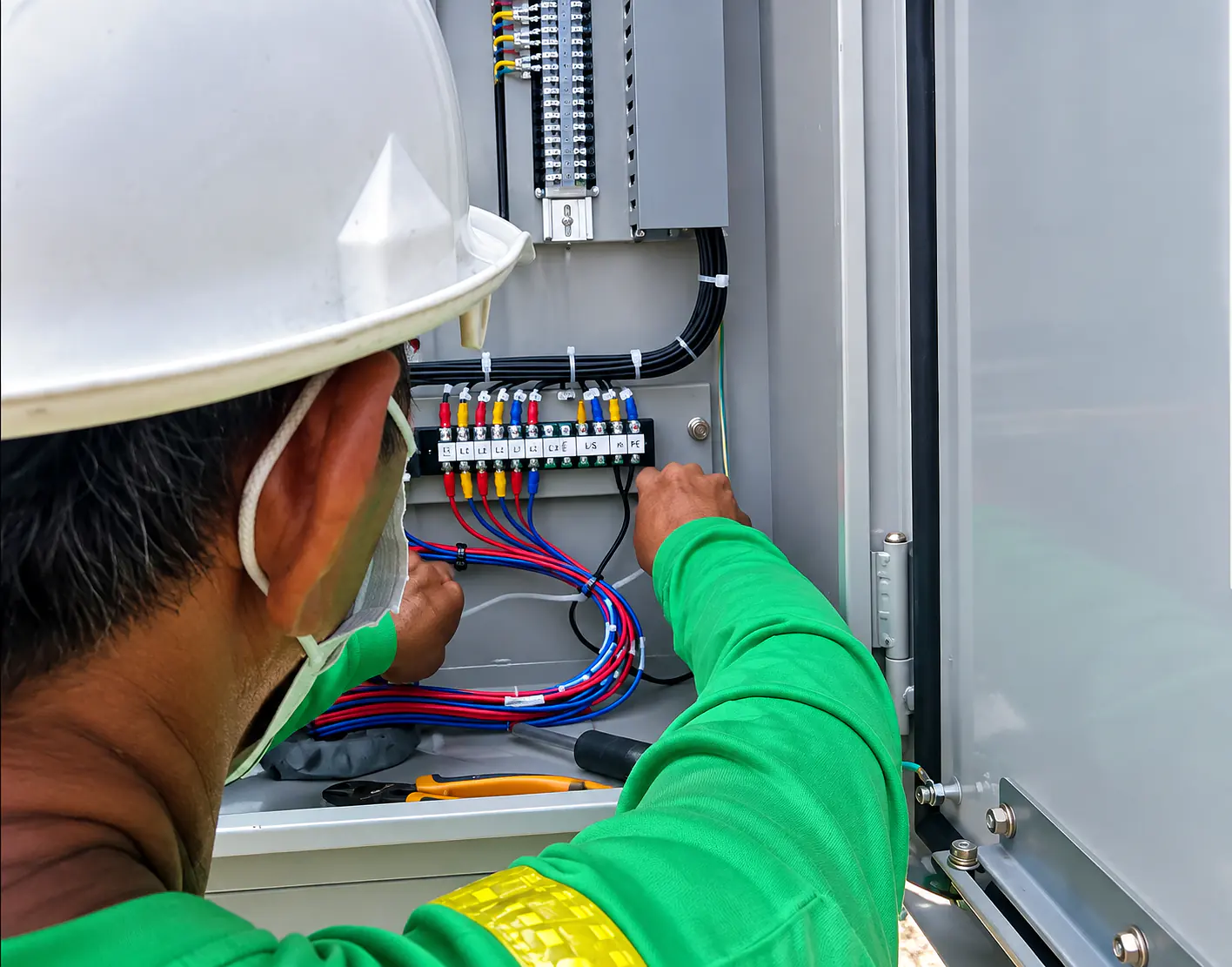 RSN technician completing precision wiring inside an irrigation control cabinet