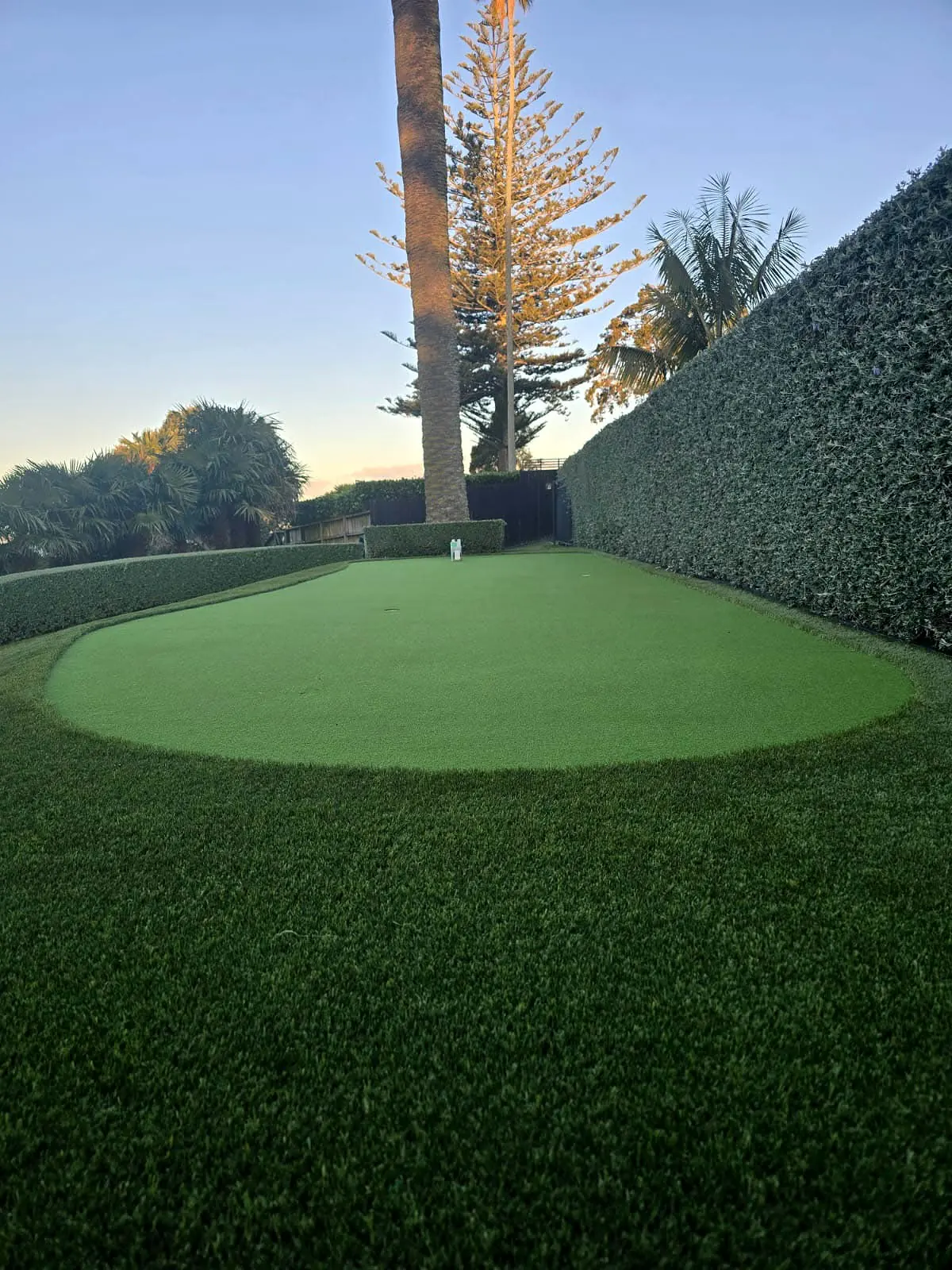 Finished artificial turf mini golf putting green with precise curved edging