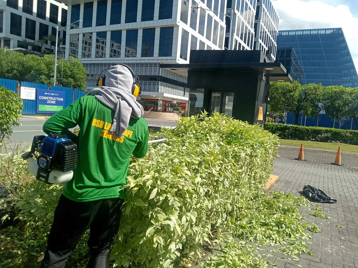 RSN crew member trimming established shrubs at a commercial property